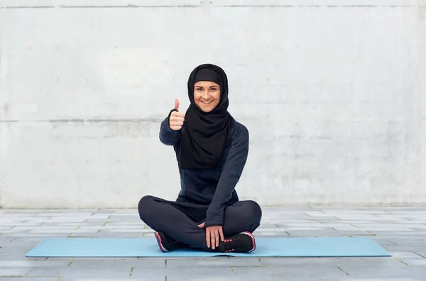 Donna musulmana facendo sport e mostrando pollici in su — Foto Stock