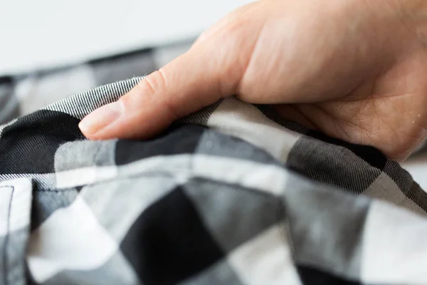 Close up of hand with checkered clothing item — Stock Photo, Image