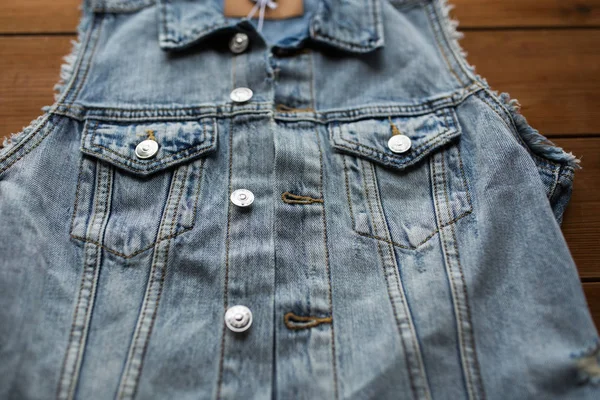 Close up of denim vest or waistcoat on wood — Stock Photo, Image