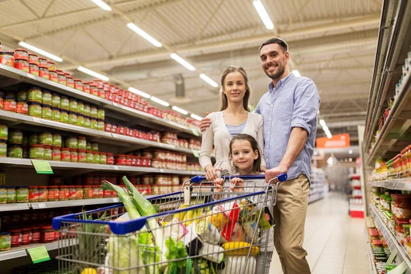 Familia con comida en el carrito de la compra en la tienda de comestibles —  Fotos de Stock