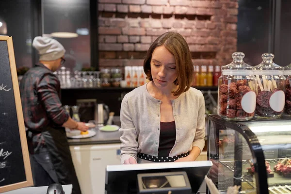 Kvinna eller barflicka med kassan på café — Stockfoto