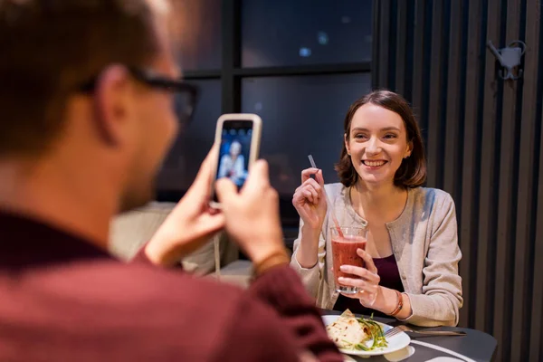 Happy couple with smartphone at vegan restaurant — Stock Photo, Image