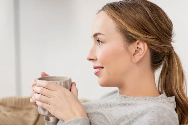 Mujer feliz con taza o taza de beber en casa — Foto de Stock