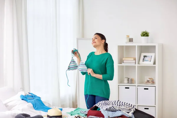 Frau mit Badeanzug packt Reisetasche zu Hause — Stockfoto