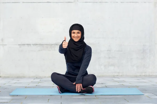 Μουσουλμανική γυναίκα κάνει αθλητισμό και δείχνει τους αντίχειρες επάνω Εικόνα Αρχείου