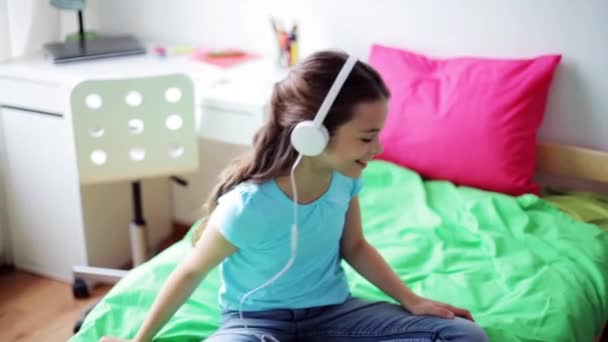 Happy girl with smartphone and headphones at home — Stock Video