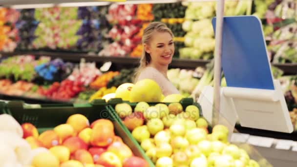 Pregnant woman with bag buying pears at grocery — Stock Video