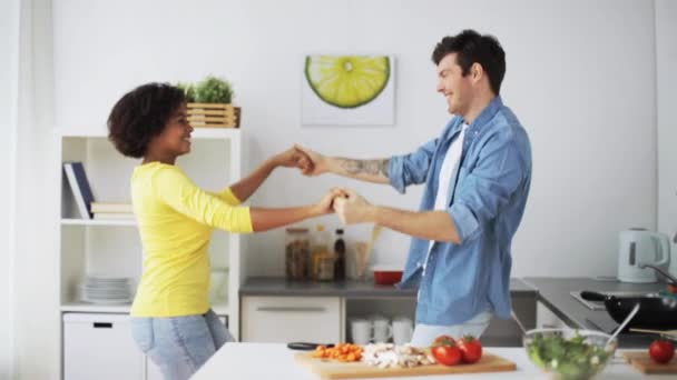 Счастливая пара готовит еду и танцует дома — стоковое видео