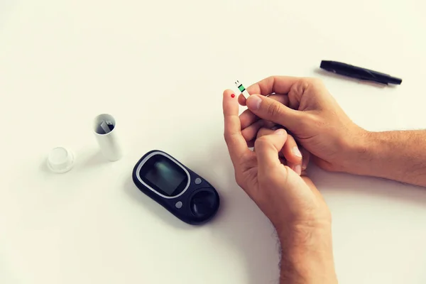 Close up of man checking blood sugar by glucometer — Stock Photo, Image