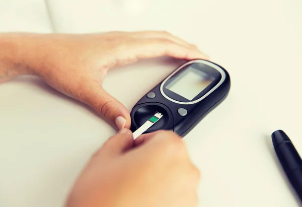 Close up van de vrouw bloedonderzoek door glucometer maken — Stockfoto