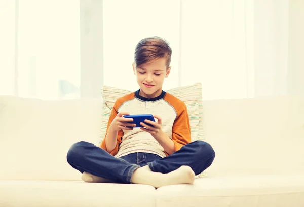 Хлопчик з смс-повідомленням або грою вдома — стокове фото
