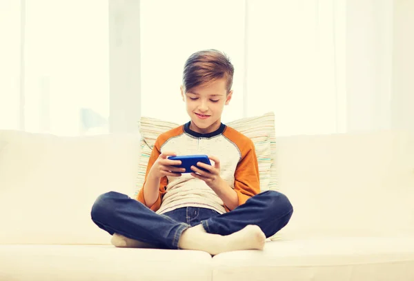 Niño con mensajes de texto de teléfonos inteligentes o jugando en casa — Foto de Stock