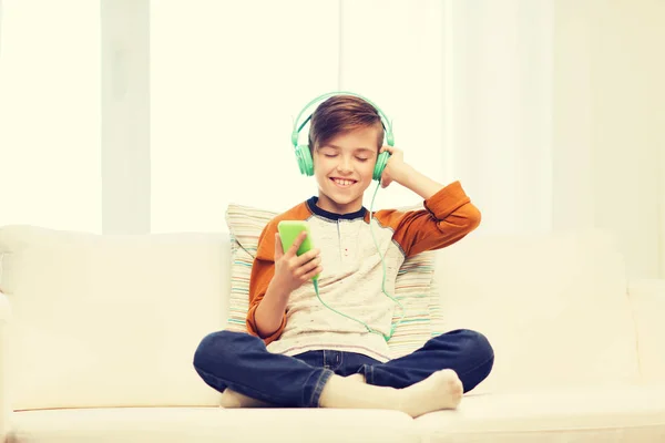 快乐的男孩，家里有智能手机和耳机 — 图库照片