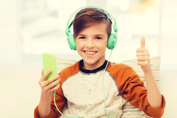 快乐的男孩，家里有智能手机和耳机 — 图库照片
