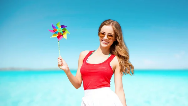 Happy woman with pinwheel over blue sky and sea — Stock Photo, Image