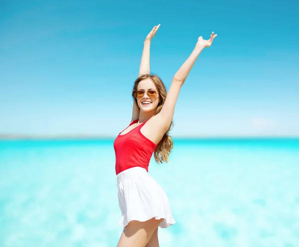 Felice giovane donna in occhiali da sole sulla spiaggia estiva — Foto Stock