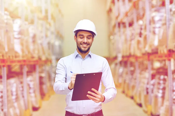 Happy businessman with clipboard at warehouse — Stock Photo, Image