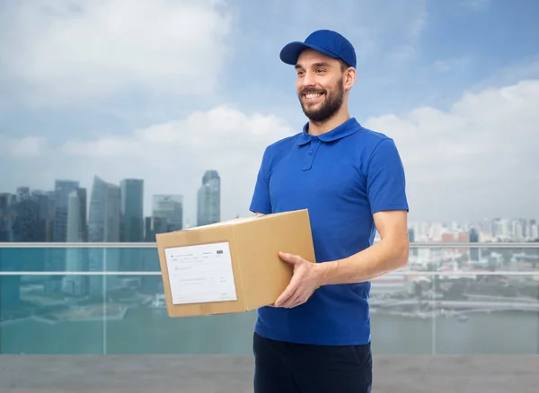 Щасливий чоловік доставки з коробкою над містом Сінгапур — стокове фото
