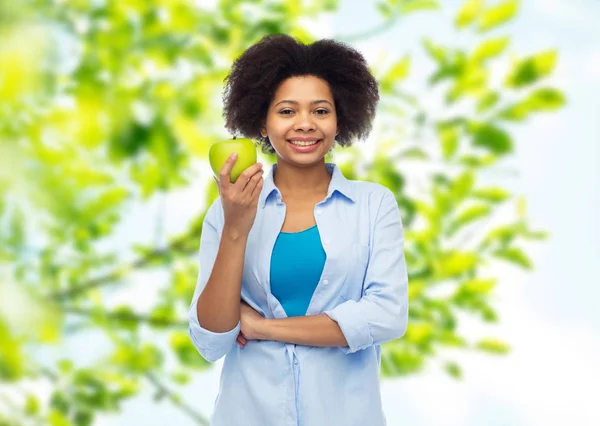 Mujer afroamericana feliz con manzana verde —  Fotos de Stock