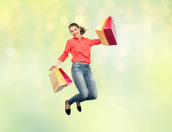 Sorridente giovane donna con shopping bags jumping — Foto Stock