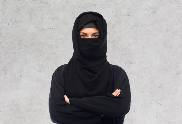 Moslimvrouw in hijab over grijze achtergrond — Stockfoto