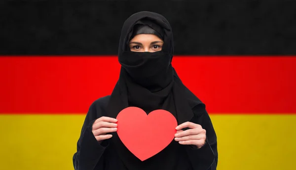 Muslim wanita dalam jilbab memegang hati merah — Stok Foto