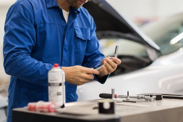 Monteur met moersleutel reparatie auto op de werkplaats — Stockfoto