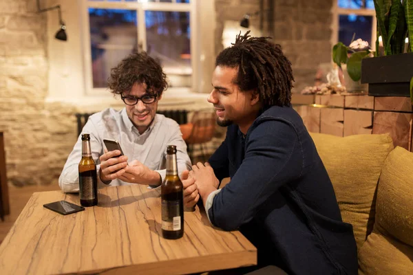 Mannen met smartphones drinken bier bij bar of pub — Stockfoto