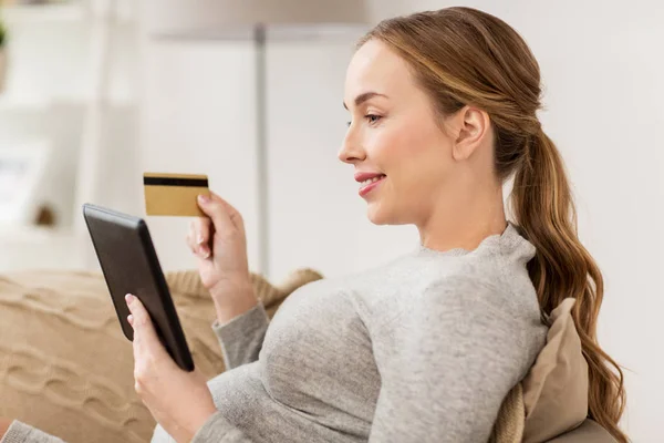 Mulher grávida com tablet pc e cartão de crédito — Fotografia de Stock