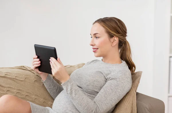 Felice donna incinta con tablet pc a casa — Foto Stock