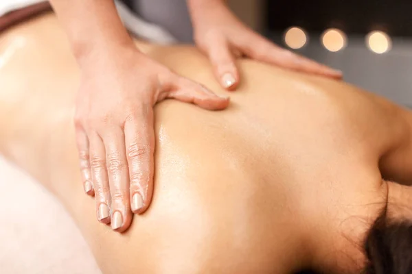 Mujer acostada y teniendo masaje de espalda en el spa —  Fotos de Stock