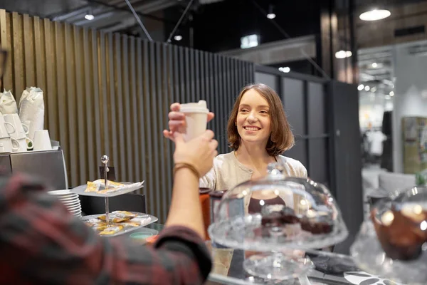 Mujer feliz tomando taza de café del vendedor en la cafetería —  Fotos de Stock