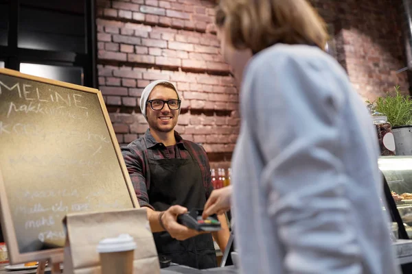 Gelukkige vrouw betalen voor aankopen bij café — Stockfoto