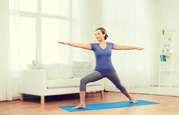 Mujer haciendo yoga guerrero pose en mat — Foto de Stock