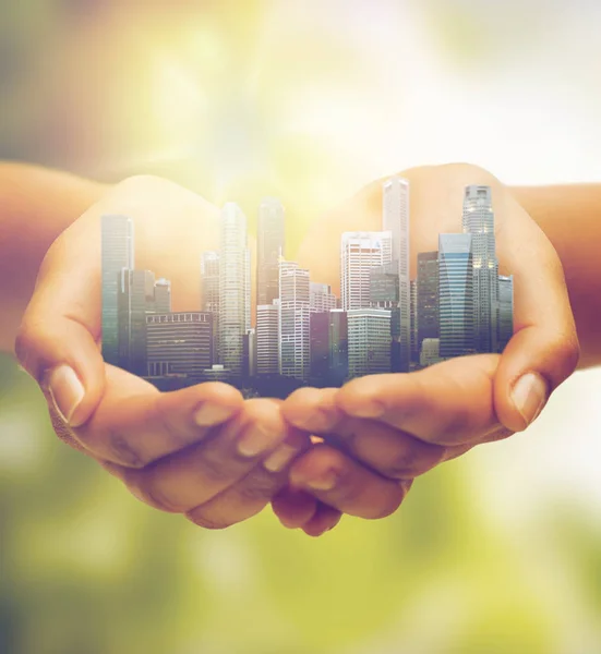 Hands holding city over green natural background — Stock Photo, Image