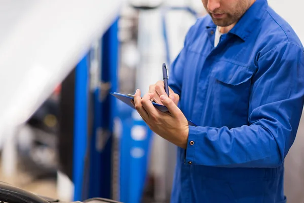 Mecánico de automóviles con portapapeles en taller de reparación de automóviles — Foto de Stock