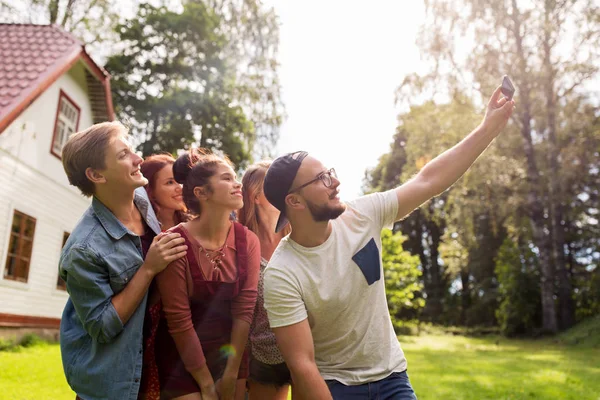 Friends taking selfie at party in summer garden — Stock Photo, Image