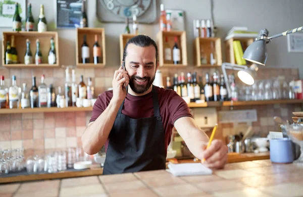 Šťastný muž, nebo číšník v baru volání na smartphone — Stock fotografie