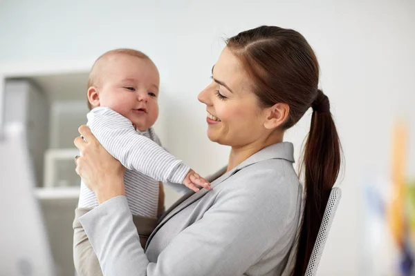 Glückliche Geschäftsfrau mit Baby im Büro — Stockfoto