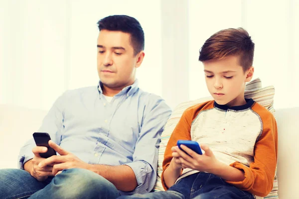 Pai e filho com smartphones em casa — Fotografia de Stock