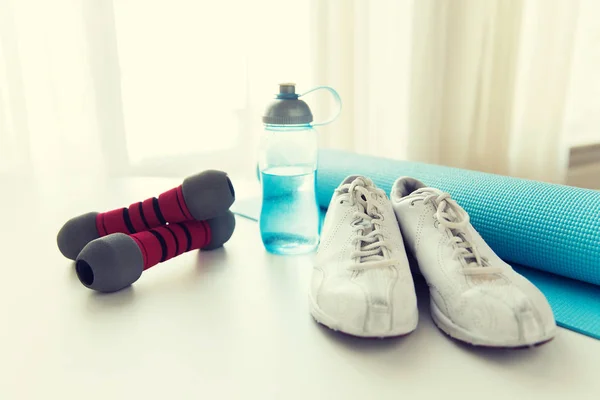 Gros plan de bouteille, haltères, baskets et tapis — Photo