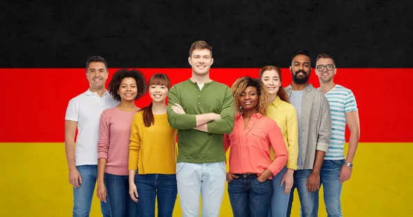 Internationale groep mensen over Duitse vlag — Stockfoto