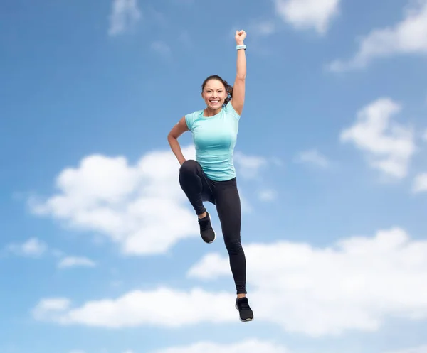 Feliz sorrindo esportivo jovem mulher pulando no ar — Fotografia de Stock
