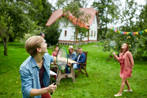 Happy friends playing badminton at summer garden — Stock fotografie
