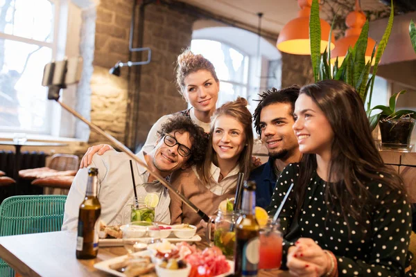 Amigos tomando selfie por smartphone no bar ou café — Fotografia de Stock