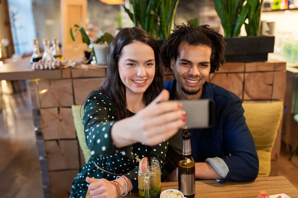 Lyckliga paret tar selfie på café eller bar — Stockfoto