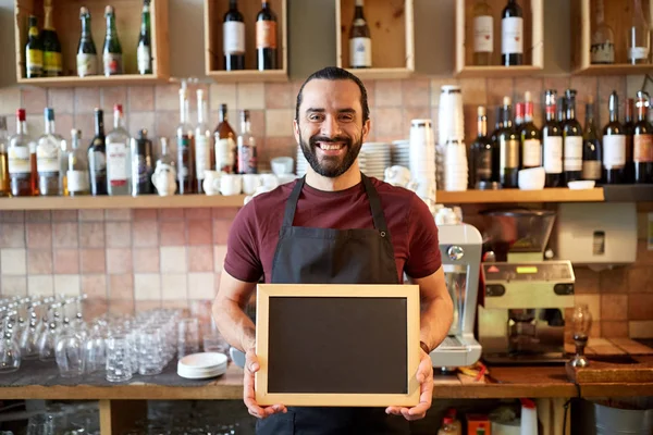 Hombre feliz o camarero con pancarta de pizarra en el bar —  Fotos de Stock