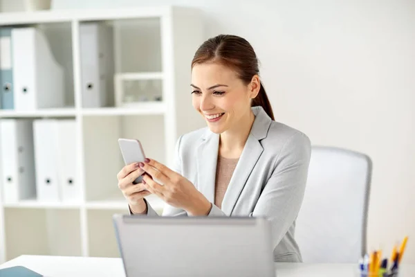 Businesswoman with smartphone at office — Stock Photo, Image