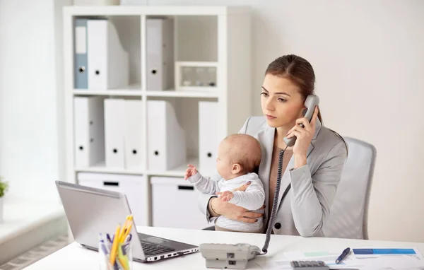 Empresária com bebê chamando no telefone no escritório — Fotografia de Stock