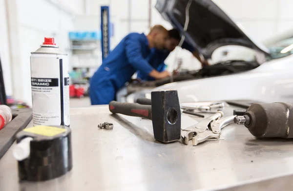 Working tools and men repairing car at workshop — Stock Photo, Image